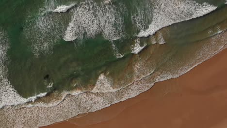 gentle waves run out onto pristine malhão beach, portugal