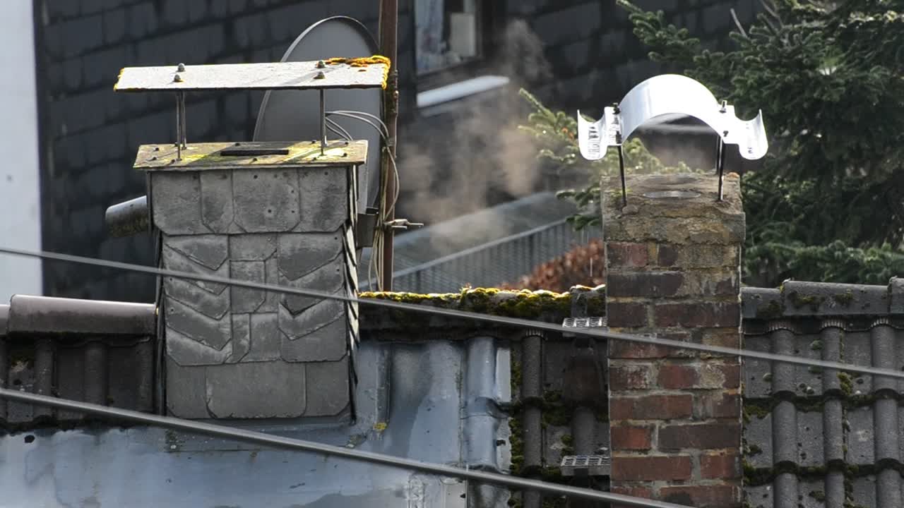 Rook komt uit een bakstenen schoorsteen tijdens zonsopgang in een Duits dorp