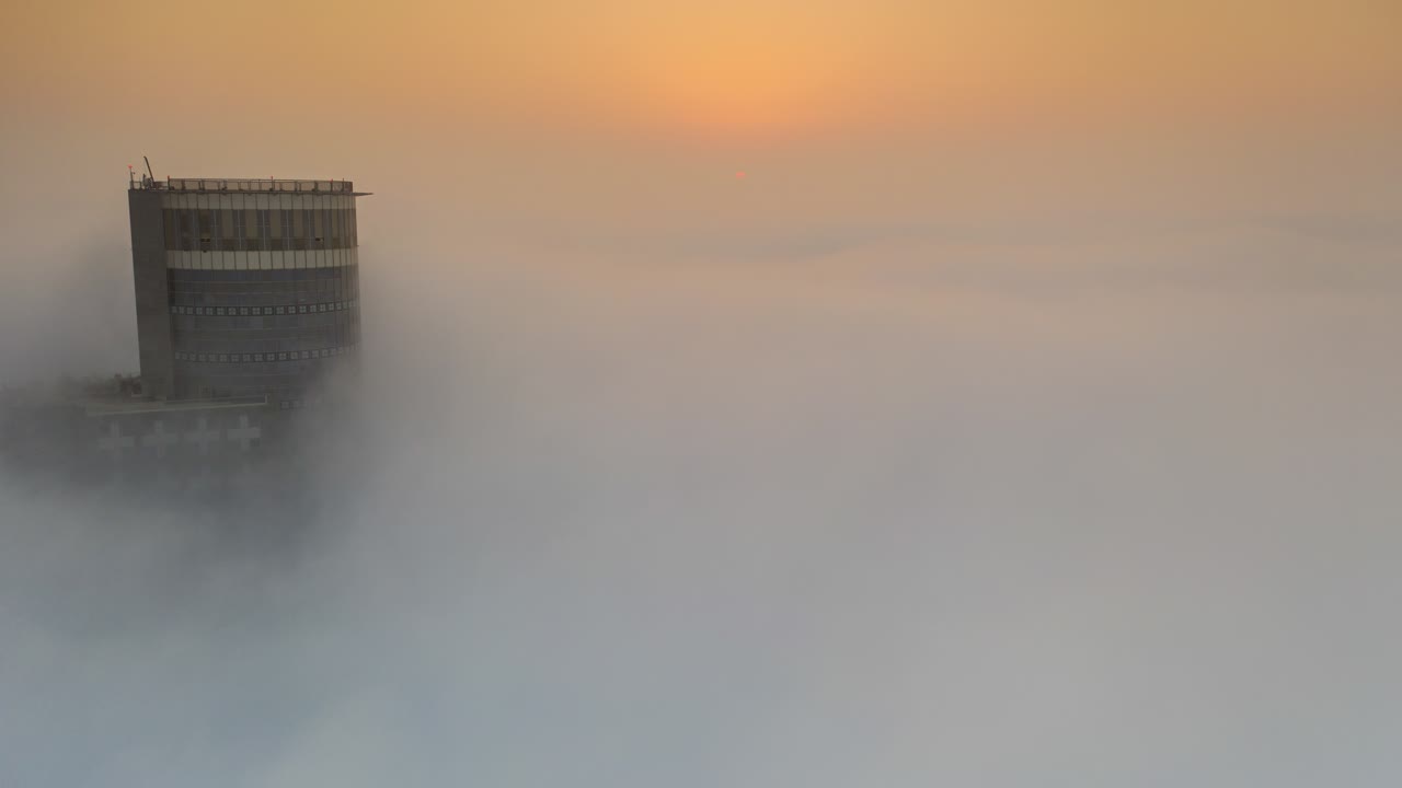 안개 속 의 마천루 위 의 해가 뜨는 것