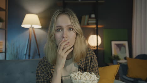 woman watching a sad movie with popcorn