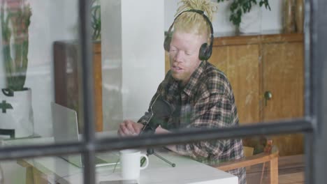 happy albino african american man with dreadlocks making podcast