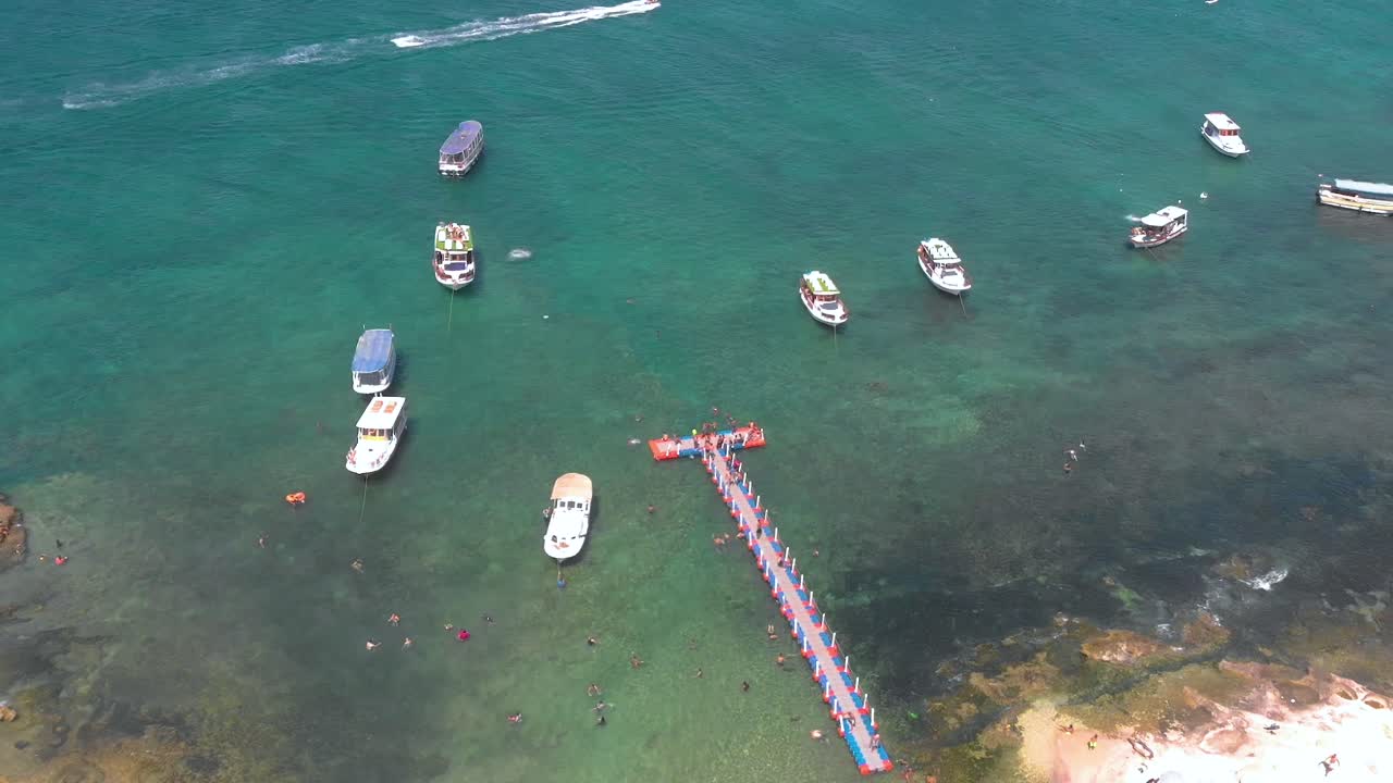 Soar above Rabbit Island's stunning coastline. Watch as people dive into azure waters and boats bob near shore. 4K aerial footage of Lebanon's gem