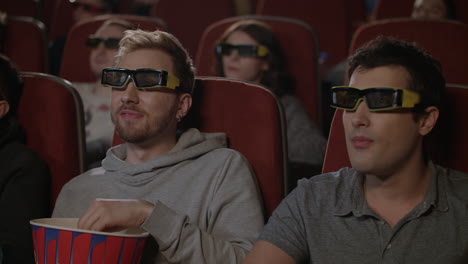 two guys in 3d glasses watching a movie in the cinema