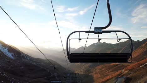 beautiful drone view of a ski lift looking at a sunset on a mountain