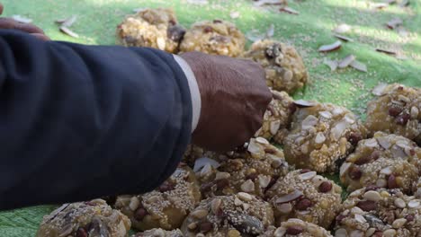 hand placing nuts onto row of jaggery lumps