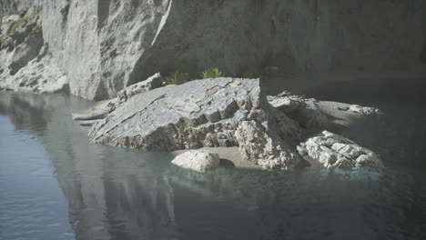 calm waters surrounding rocky outcrop at daytime