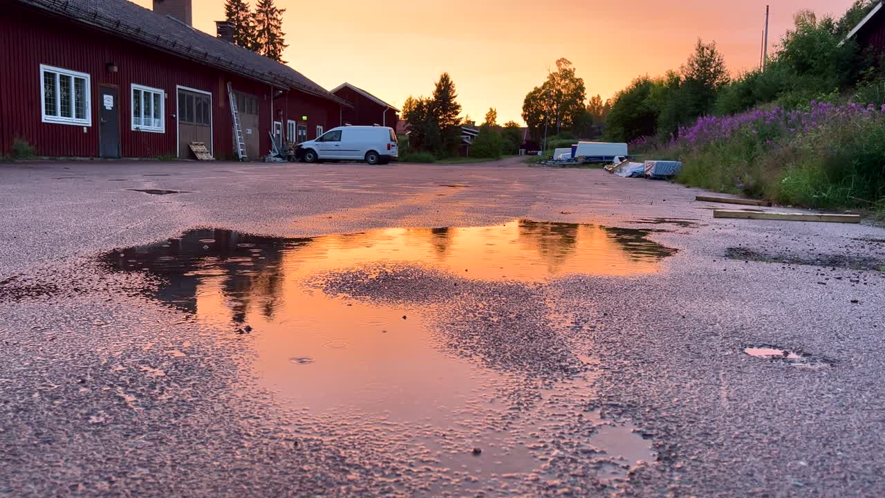 llovizna de verano en un charco de agua con reflejos durante la puesta de sol