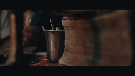 an old pirate capitan smokes a pipe inside the sailing ship cabin