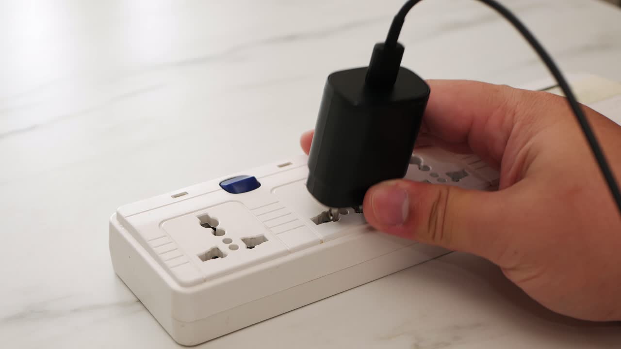 남자 손을 닫고 전화 어댑터 배터리를 뽑고 충전기를 제거하여 스위치를 끕니다.