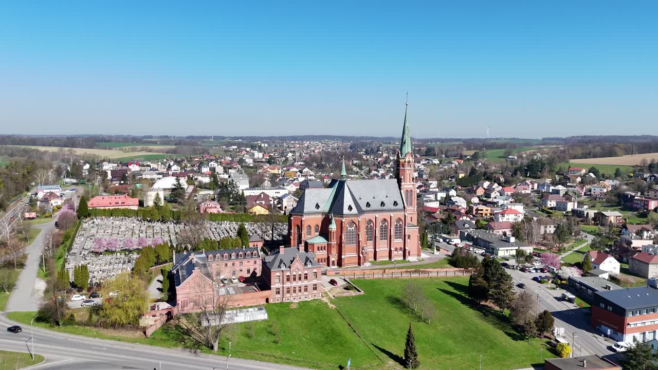 High angle aerial orbit of Ludgerovice showing full church, village layout and surrounding hills