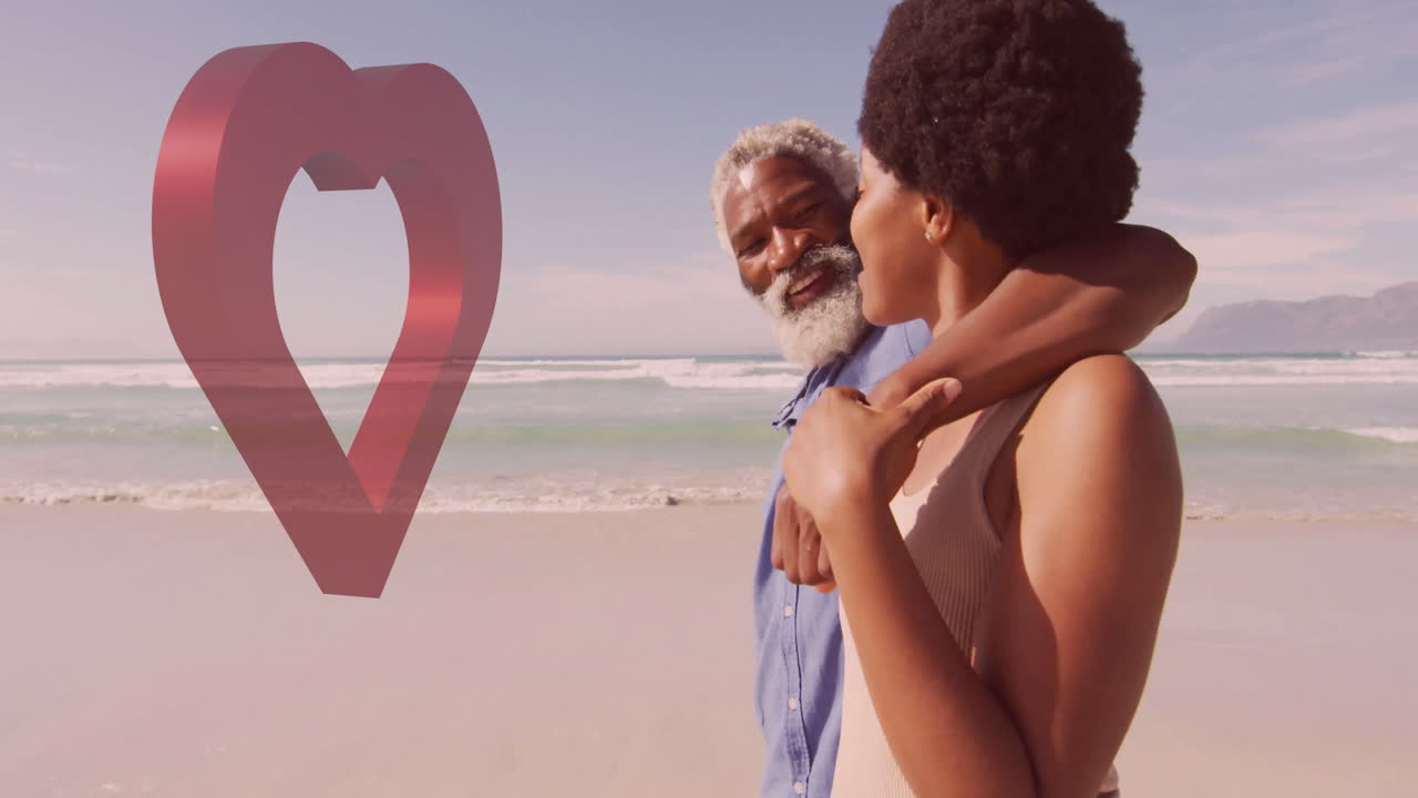Elderly man and young woman walking on beach with heart animation overlay