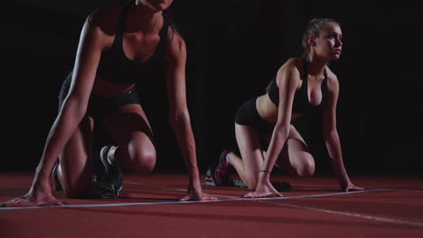 atletas femeninas calentándose en la pista de atletismo antes de una carrera. en cámara lenta