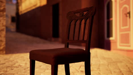 antique wooden chair on a cobblestone street at sunset