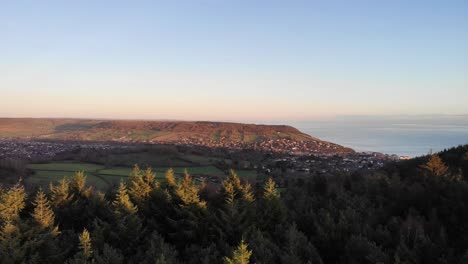 aerial panning right shot of sidmouth devon at sunset with a beautiful blue sky and sea