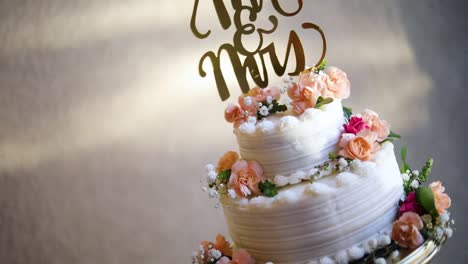 Smooth-shot-of-a-beautifully-decorated-wedding-cake-on-a-fancy-platter-at-a-wedding-reception