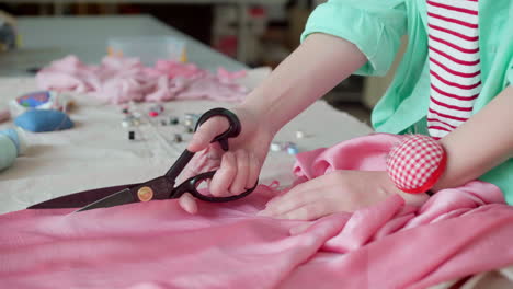 dressmaker cutting fabric.