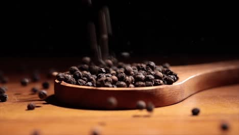 Black-Tellicherry-peppercorns-closeup-in-wooden-spoon-on-a-kitchen-table.