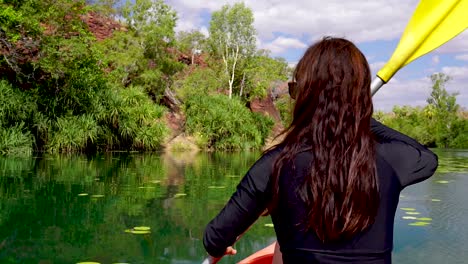 chica en canoa por un río panorámico en un oasis en el interior de australia