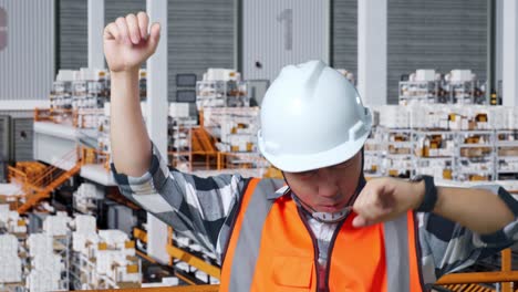 primer plano de ingeniero masculino asiático con casco de seguridad gritando gol y bailando celebrando mientras estaba de pie en el almacén con estantes llenos de mercancías de entrega