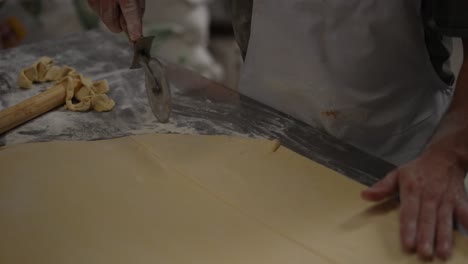 artisan bakery, baker making bread and pastry, dough kneading, wheel cutter, baker's hands