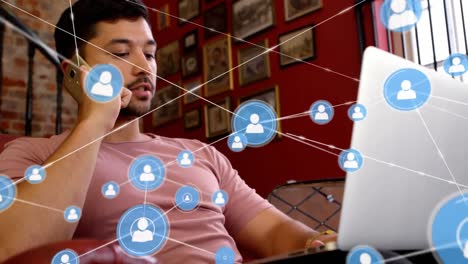 Animation-of-network-of-connections-with-icons-over-man-using-smartphone-and-laptop