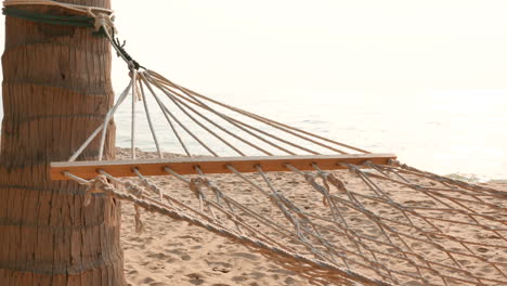 Empty-hammock-on-the-beautiful-beach-and-sea-at-sunrise-time