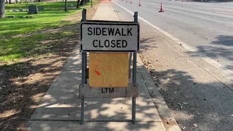 Sidewalk-closed-sign-on-the-side-of-the-road-in-the-shade