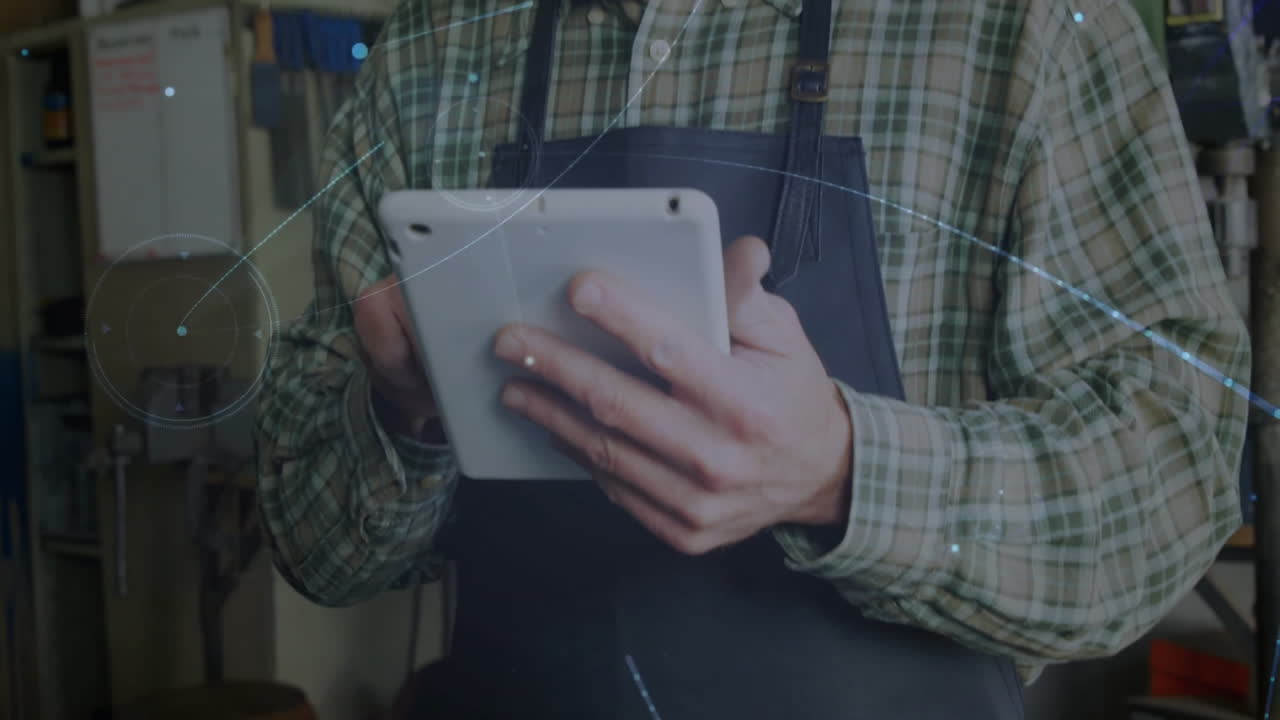Using tablet with digital animation overlay, man in plaid shirt working