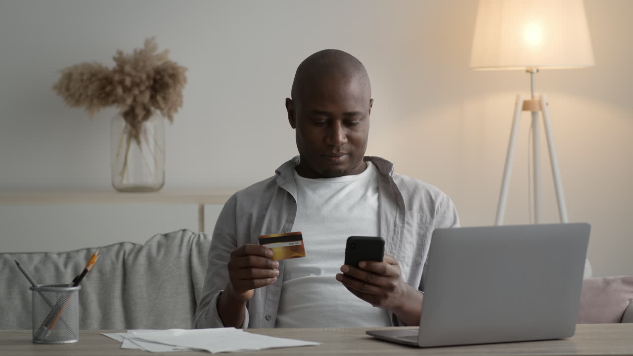 Uomo che usa il cellulare e la carta di credito