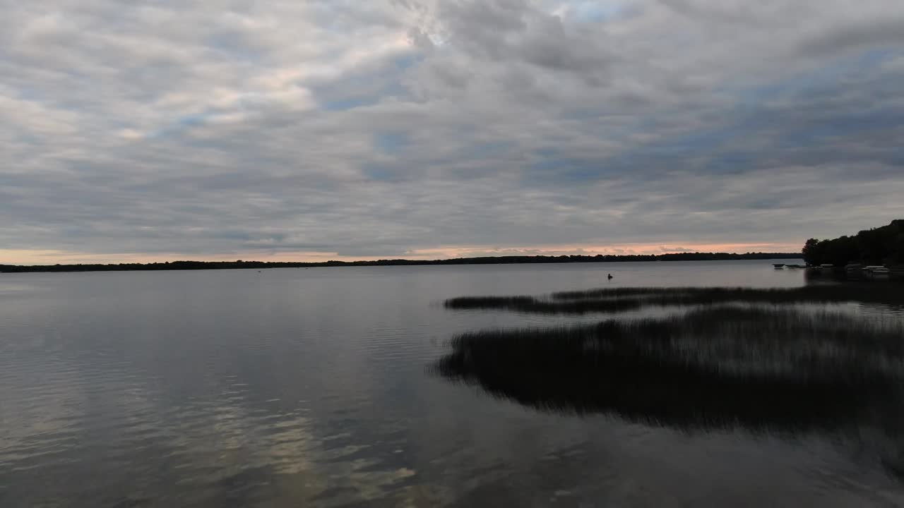drone volando sobre un lago tranquilo al atardecer, imágenes de 4k