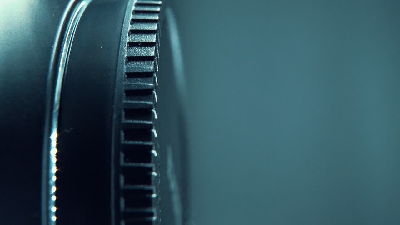 A vertical macro close up shot of a black plastic wheel on a shiny 360 rotating stand, cinematic studio lighting, 120 fps, Slow motion, Full HD video