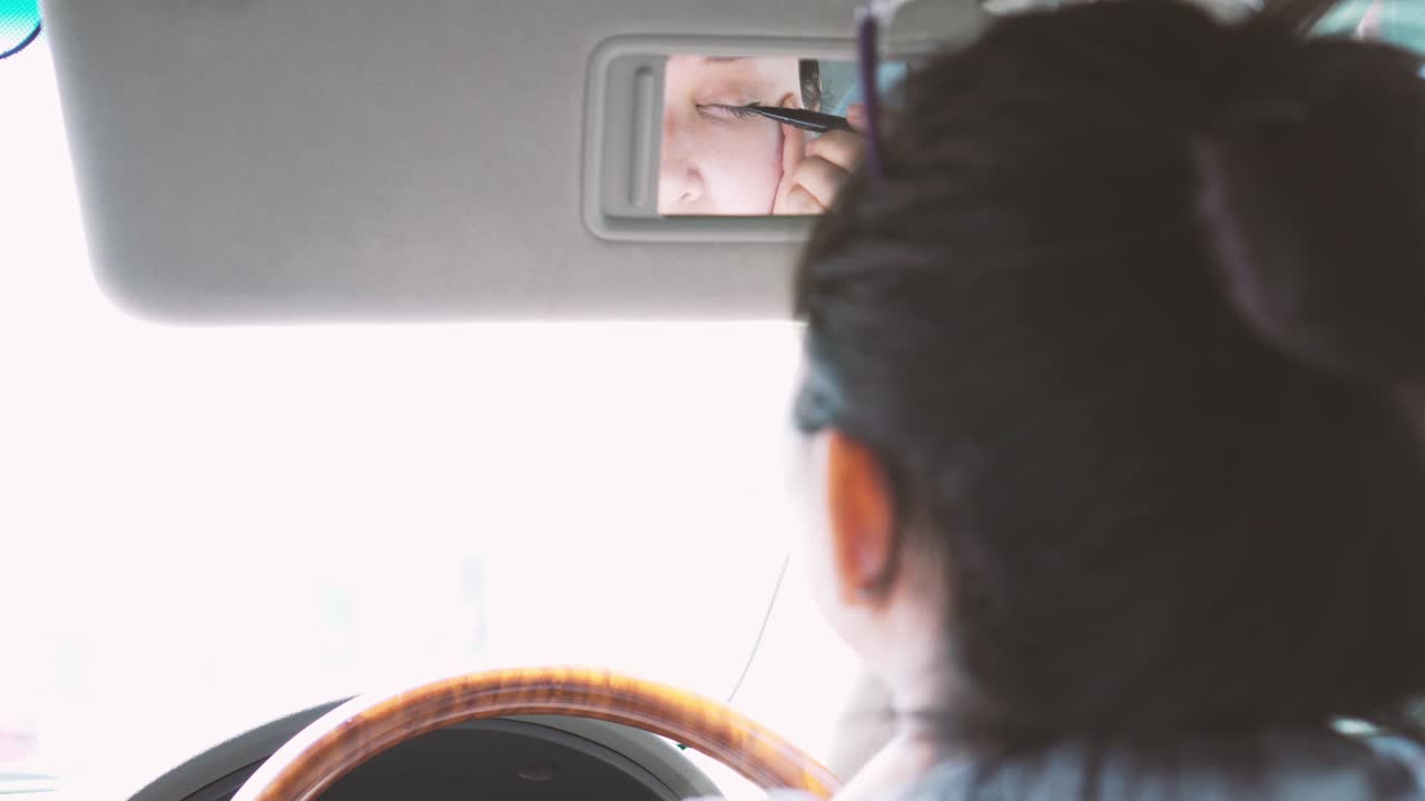 자동차를 운전하는 여자와 메이크업