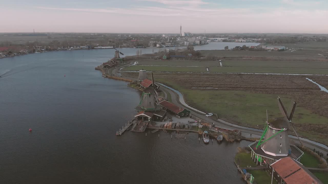 푸른 하늘이 있는 밝은 날에 심지가 회전하는 전형적인 네덜란드 풍경의 풍차에 대한 공중 전망