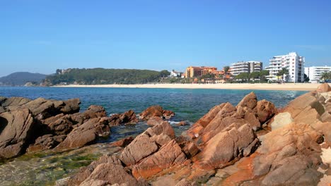 Fenals-En-Lloret-De-Mar-Costa-Brava,-Imágenes-De-La-Playa,-Con-Rocas-En-Primer-Plano-Mar-Mediterráneo