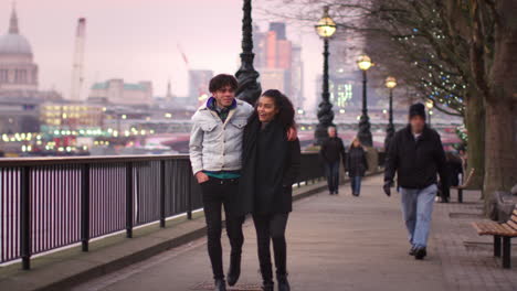 pareja caminando por la orilla sur en una visita de invierno a londres