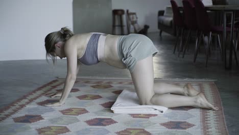 Focused-pregnant-woman-stretching-at-home