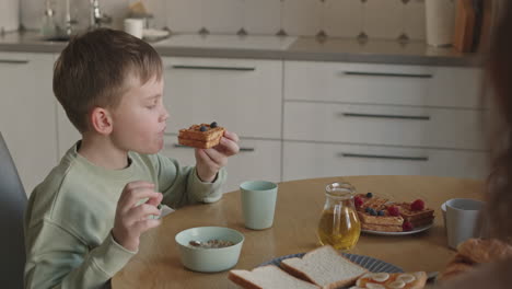 cute boy eating waffles for breakfast
