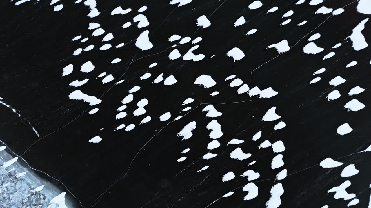 Tromsø fjords with scattered ice and dark waters, serene winter landscape, aerial view
