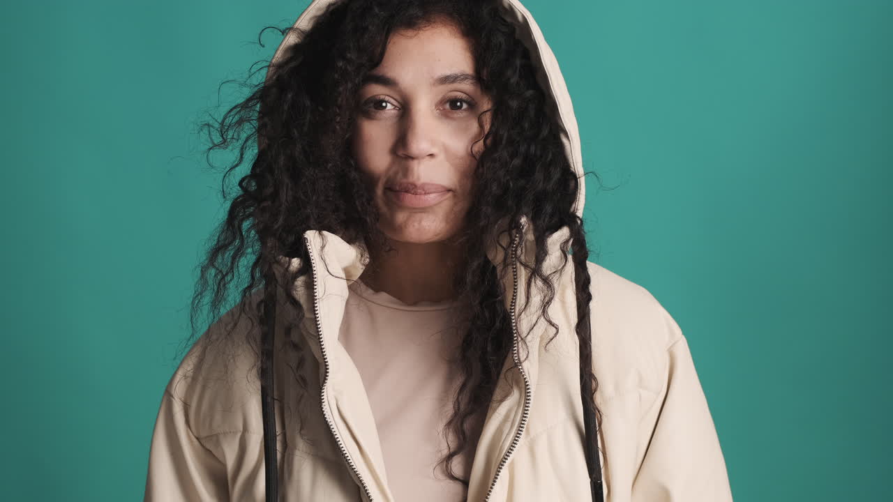 una mujer afroamericana sonriente sobre un fondo azul.