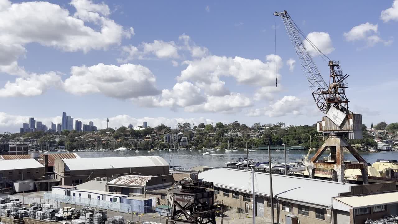 A large rusty crane standing tall over the marina with the city in the distance, on the historical industrial Cockatoo Island in Sydney harbour, Australia