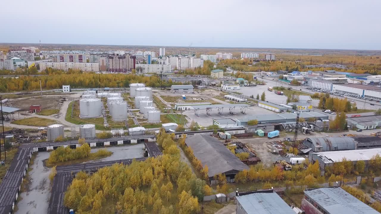 промышленная зона с нефтяными резервуарами и городским пейзажем