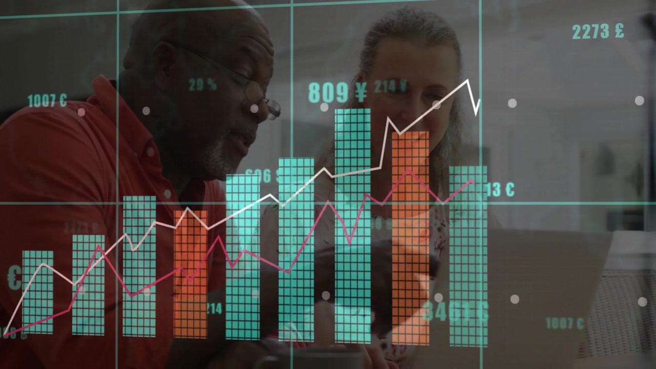 Upon senior man pointing at laptop and woman tapping keyboard, financial charts animating growth