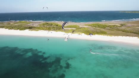 Man-Kiteboard-A-Lo-Largo-De-La-Playa-De-Arena-Blanca,-Isla-Crasqui,-De-Derecha-A-Izquierda