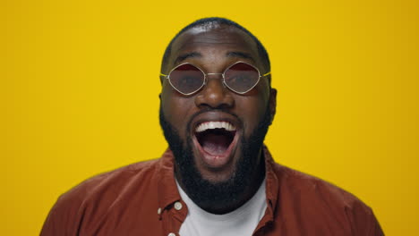 Portrait-of-surprised-african-american-man-posing-on-yellow-background.