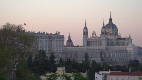 madrid, spain - spanish flag on top of madrid castle near catedral de la almudena during sunrise - a beautiful tourist destination - static shot