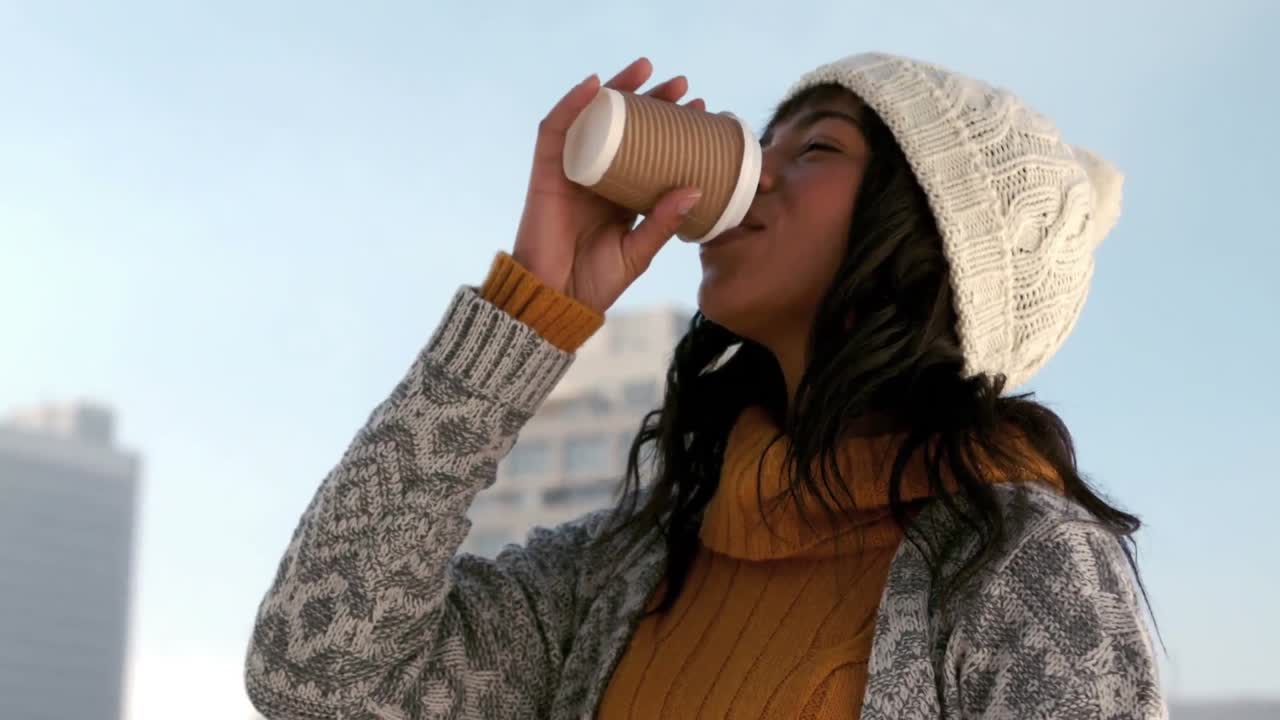 mujer disfrutando de una bebida caliente en el día de invierno