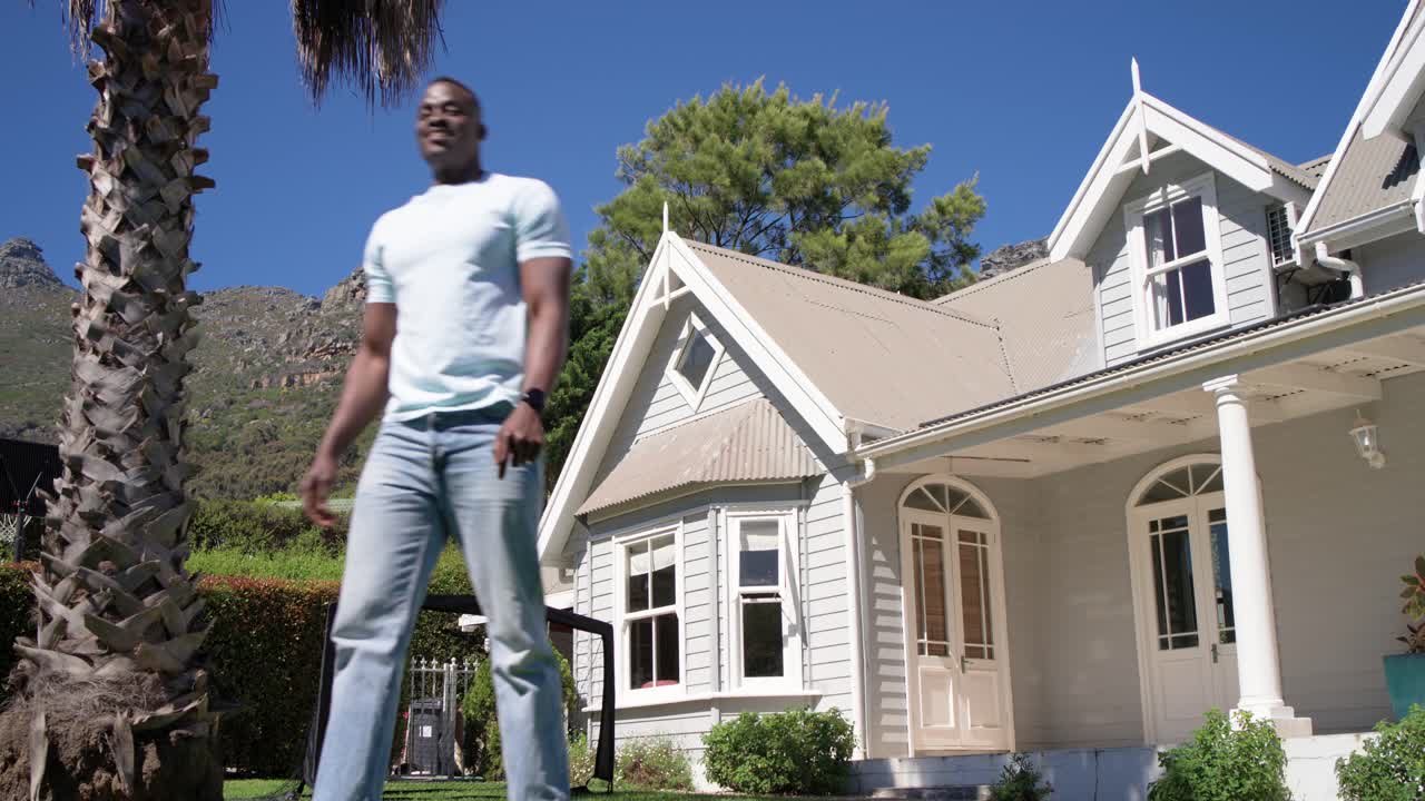 Child moving in to challenge father, dribbling soccer ball and passing on front lawn for drill