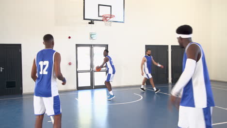 multiracial male basketball players training and playing basketball, passing and throwing in gym
