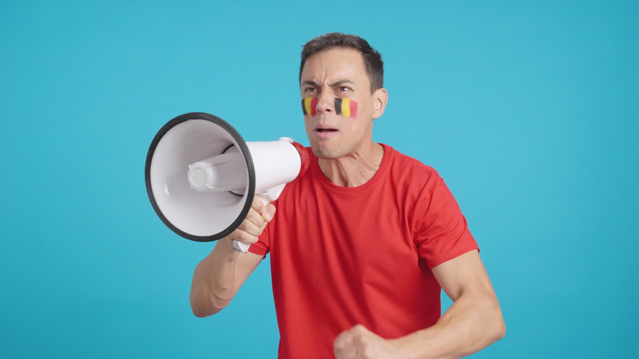 Excited man with belgian flag on face using a megaphone