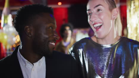 video of diverse happy couple walking into nightclub talking and laughing